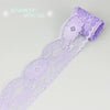 A roll of light purple decorative lace ribbon used for crafting or decoration.