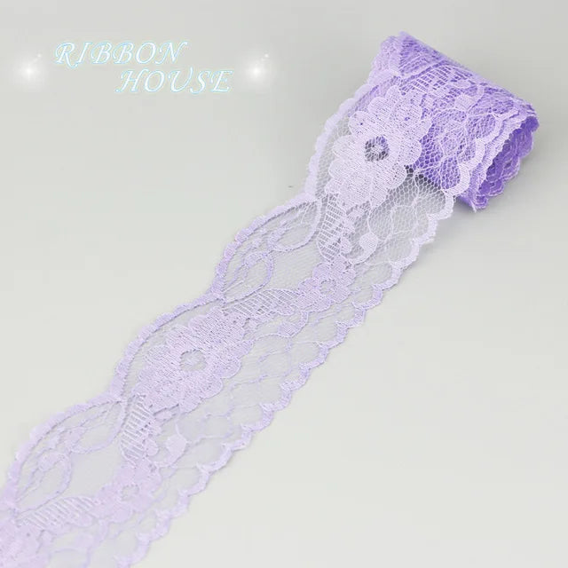 A roll of light purple decorative lace ribbon used for crafting or decoration.