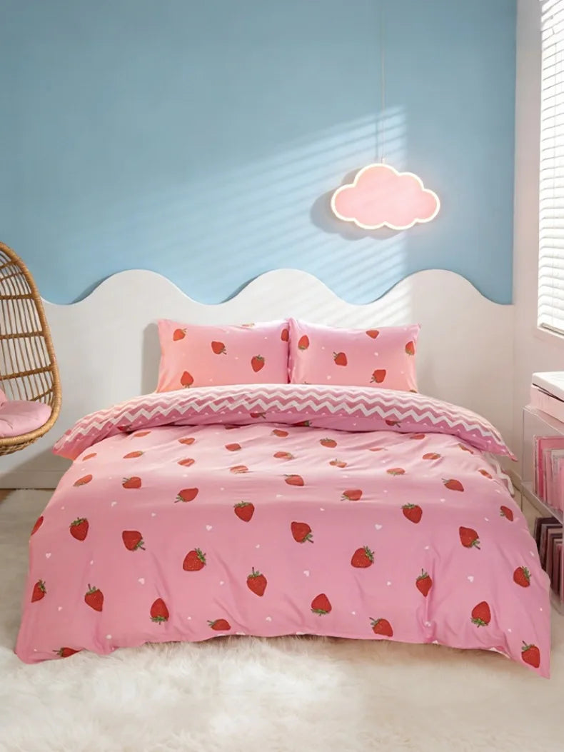 Pink strawberry print duvet cover set displayed on a white bed with a light blue wall and a cloud light.