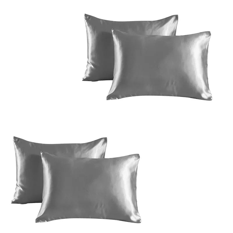 A set of three smooth, silver satin silk pillowcases.