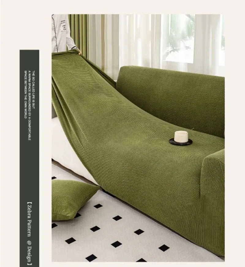 A deep olive green stretch jacquard sofa slipcover in a modern living room setting.