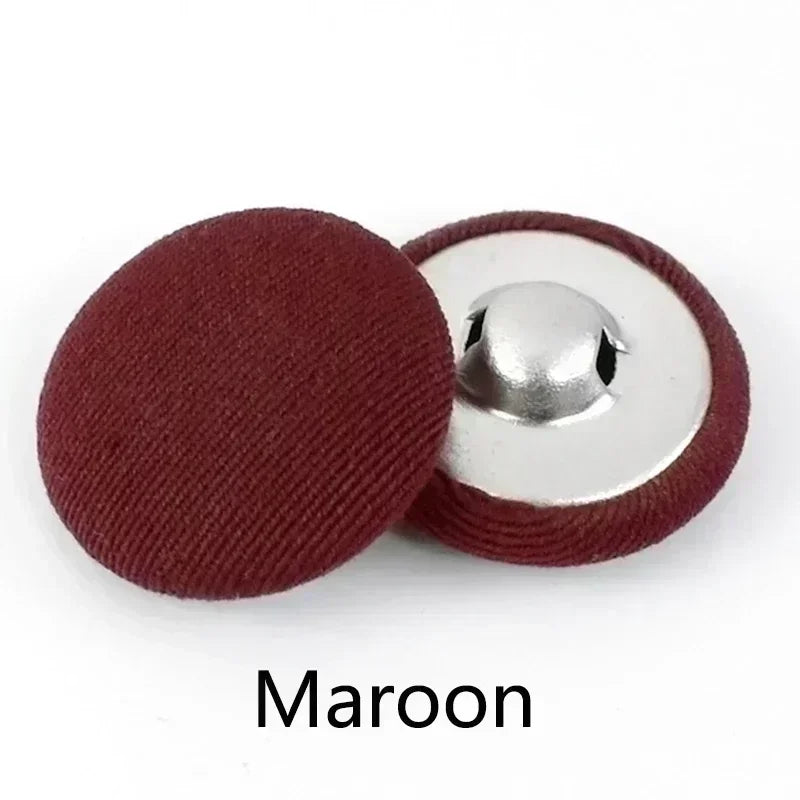 A maroon fabric-covered shank button with a silver base, shown against a white background.