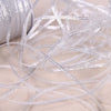 A close-up of gold and silver glitter satin ribbon strands lying on a light fabric.