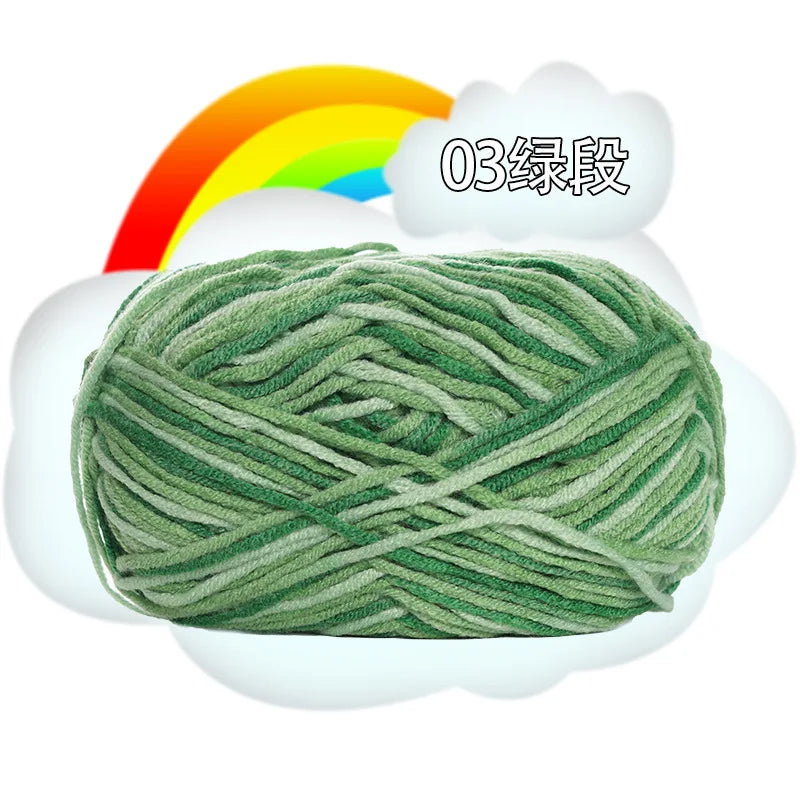 A ball of green premium milk cotton yarn labeled as 03 level, set against a white cloud and a rainbow background.