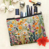 A floral canvas cosmetic bag with a zipper closure featuring various makeup and skincare products.
