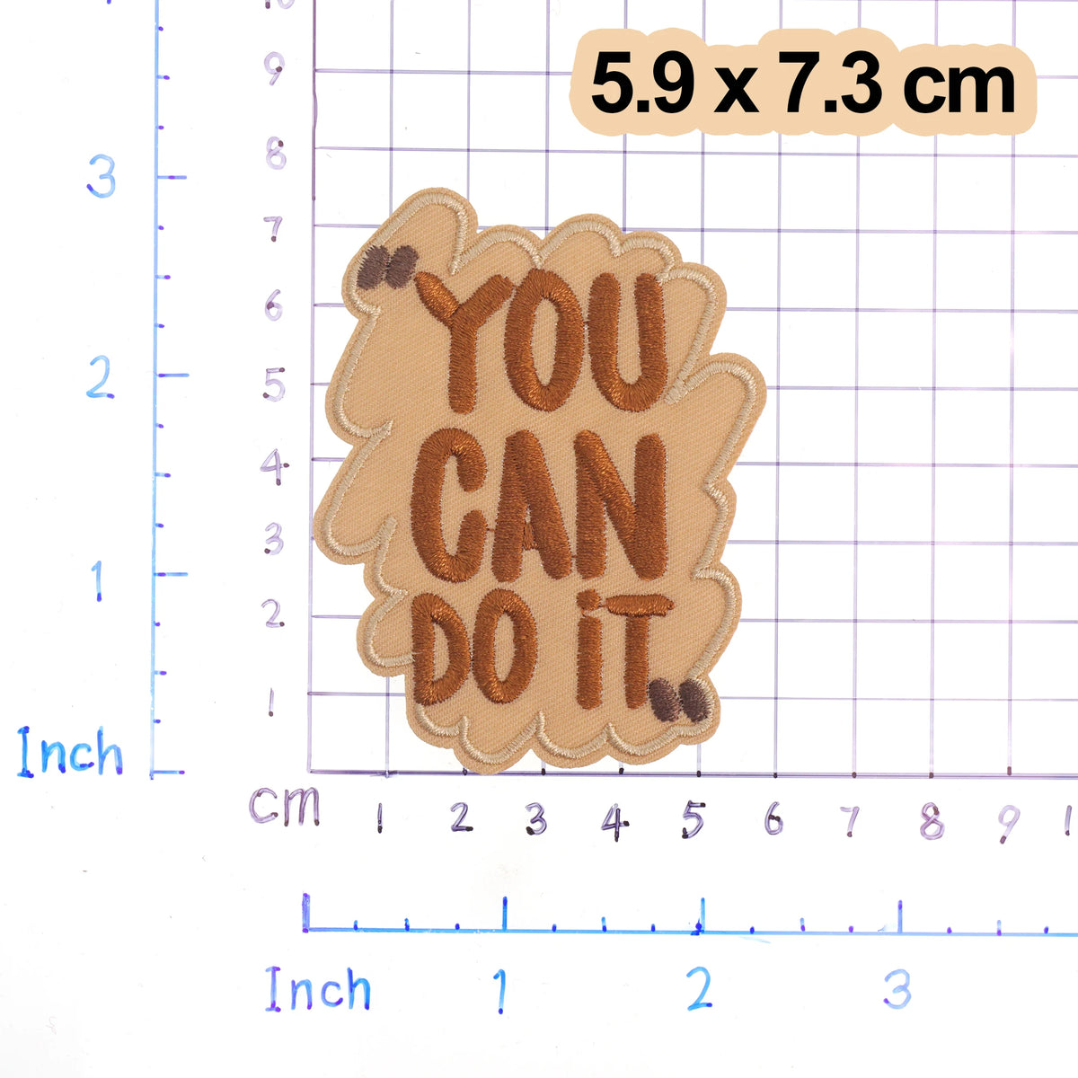 A brown iron-on embroidered patch with the text YOU CAN DO IT on a light tan fabric, measuring 5.9 x 7.3 cm.