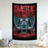 A dark tapestry featuring a red and black graphic of a skull with intense facial expression and surrounding text.
