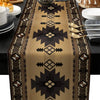 A tan linen table runner with an Indian-inspired geometric pattern featuring dark brown and gold accents.
