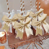 Gold satin bowknot ribbons tied around clear glass jars filled with glitter
