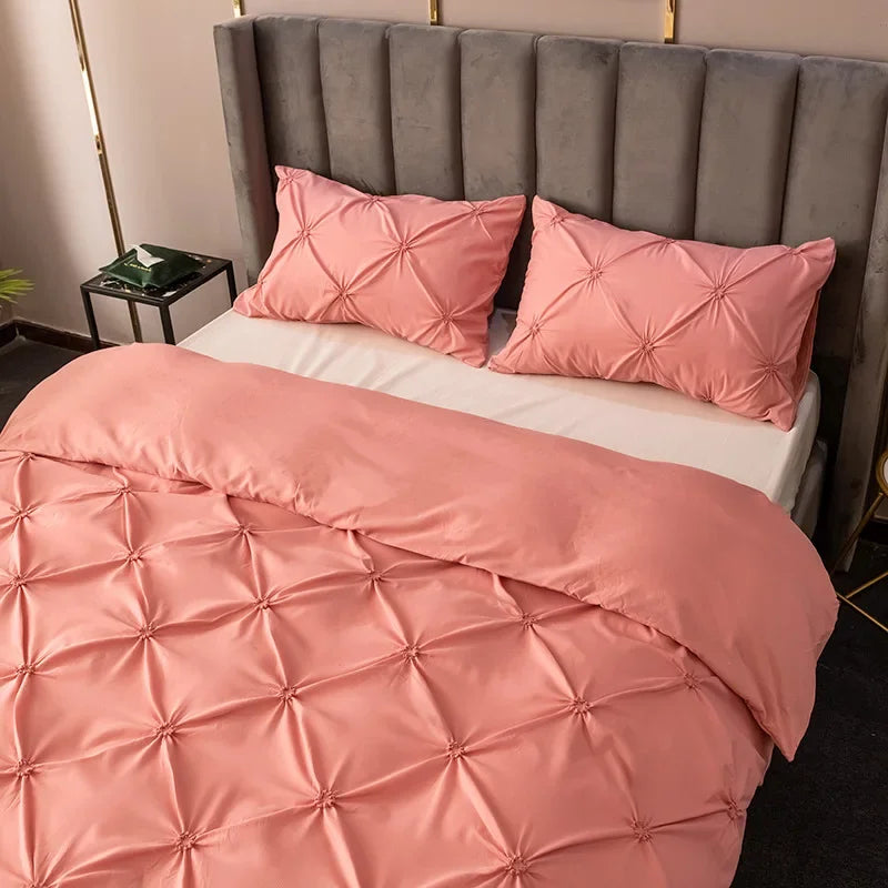 Pink quilted bedding set featuring a headboard and pillows in a soft satin finish.