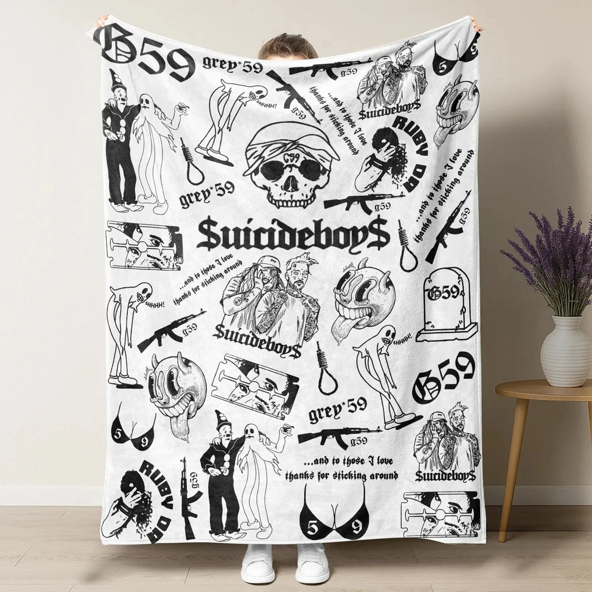 A white blanket featuring a retro punk style print with skulls, symbols, and text like Suicideboys and grey 59.