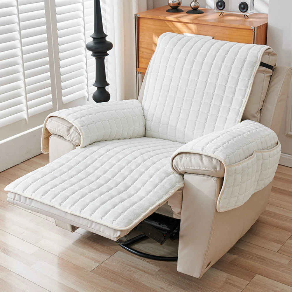 A beige quilted stretch recliner cover with storage pockets shown on a wooden floor.
