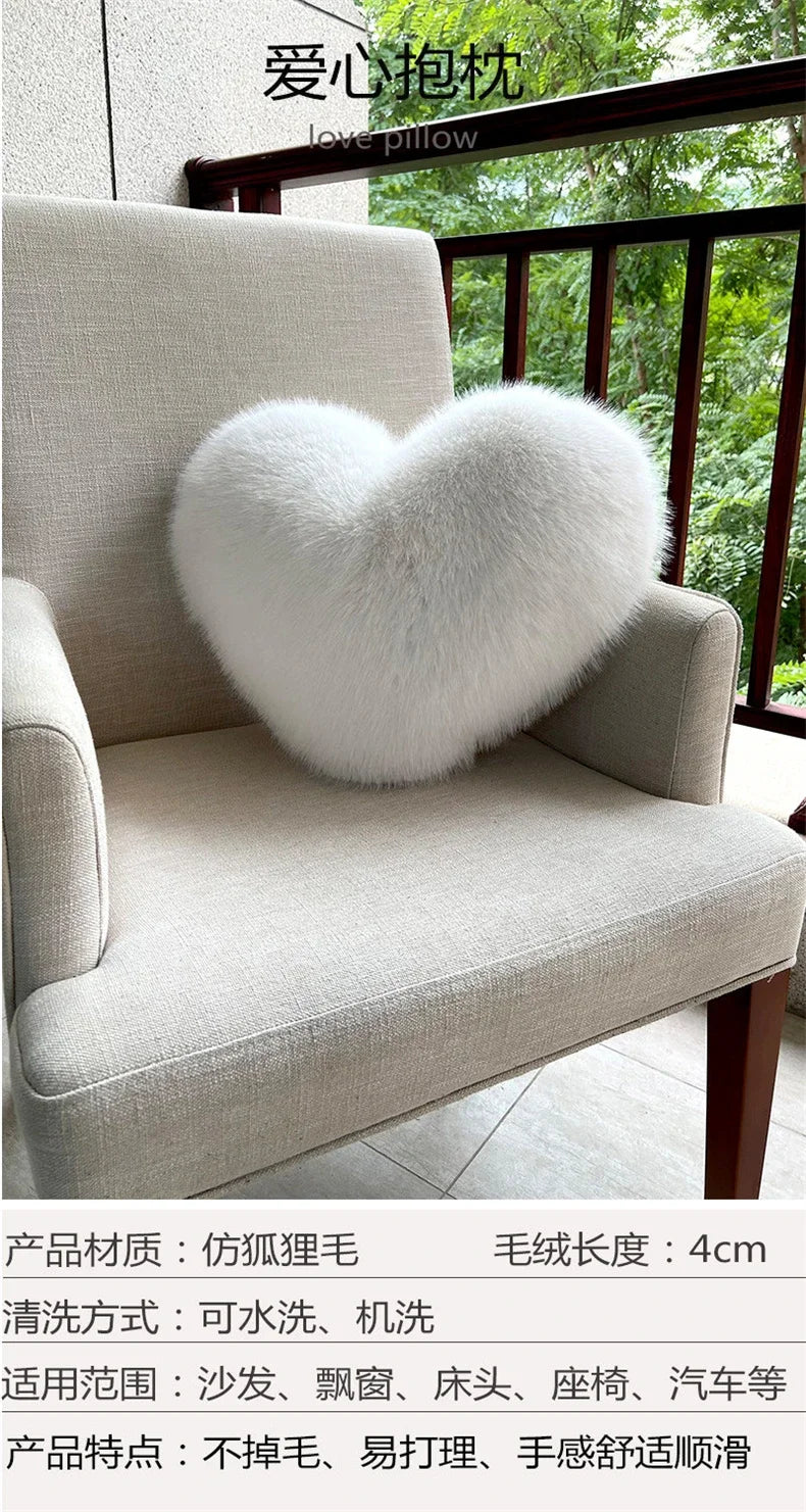 A fluffy white heart-shaped pillow made of fox fur resting on a light beige armchair.