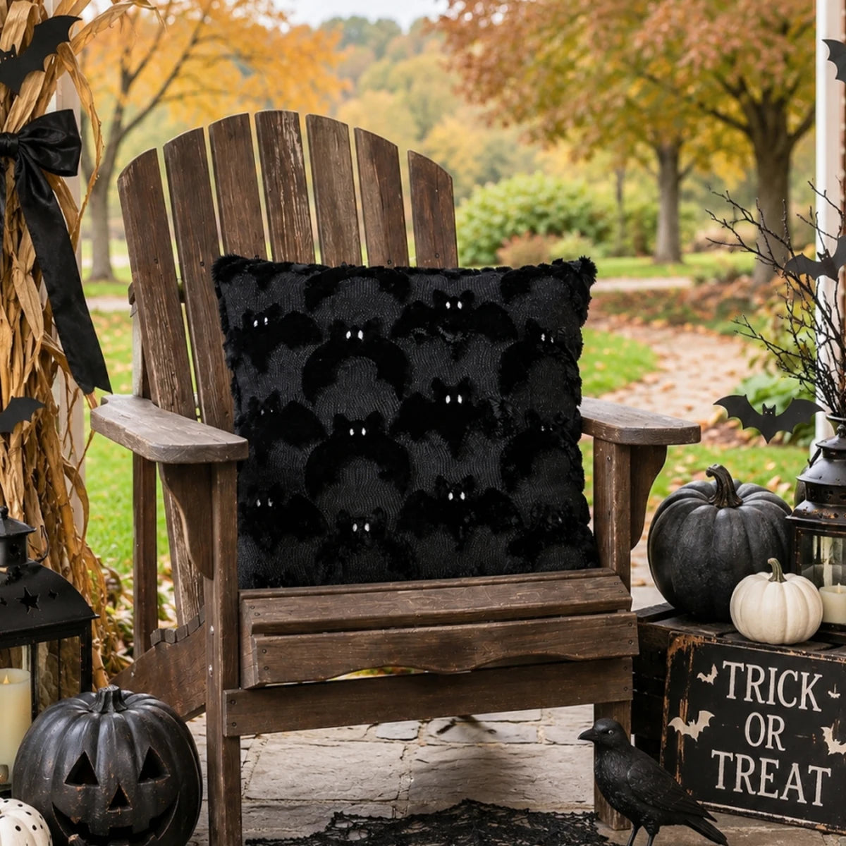 A wooden chair decorated for Halloween featuring a black bat plush cushion cover and pumpkins.