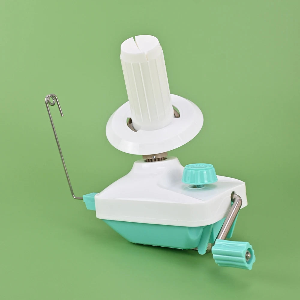 A white hand-operated wool yarn winder device with a green base and a white spindle.