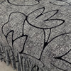 A pleated fabric sofa cover featuring a black silhouette of a tree design on a gray background.