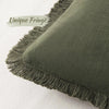 A close-up of a moss green linen throw pillow cover with unique fringe detail.