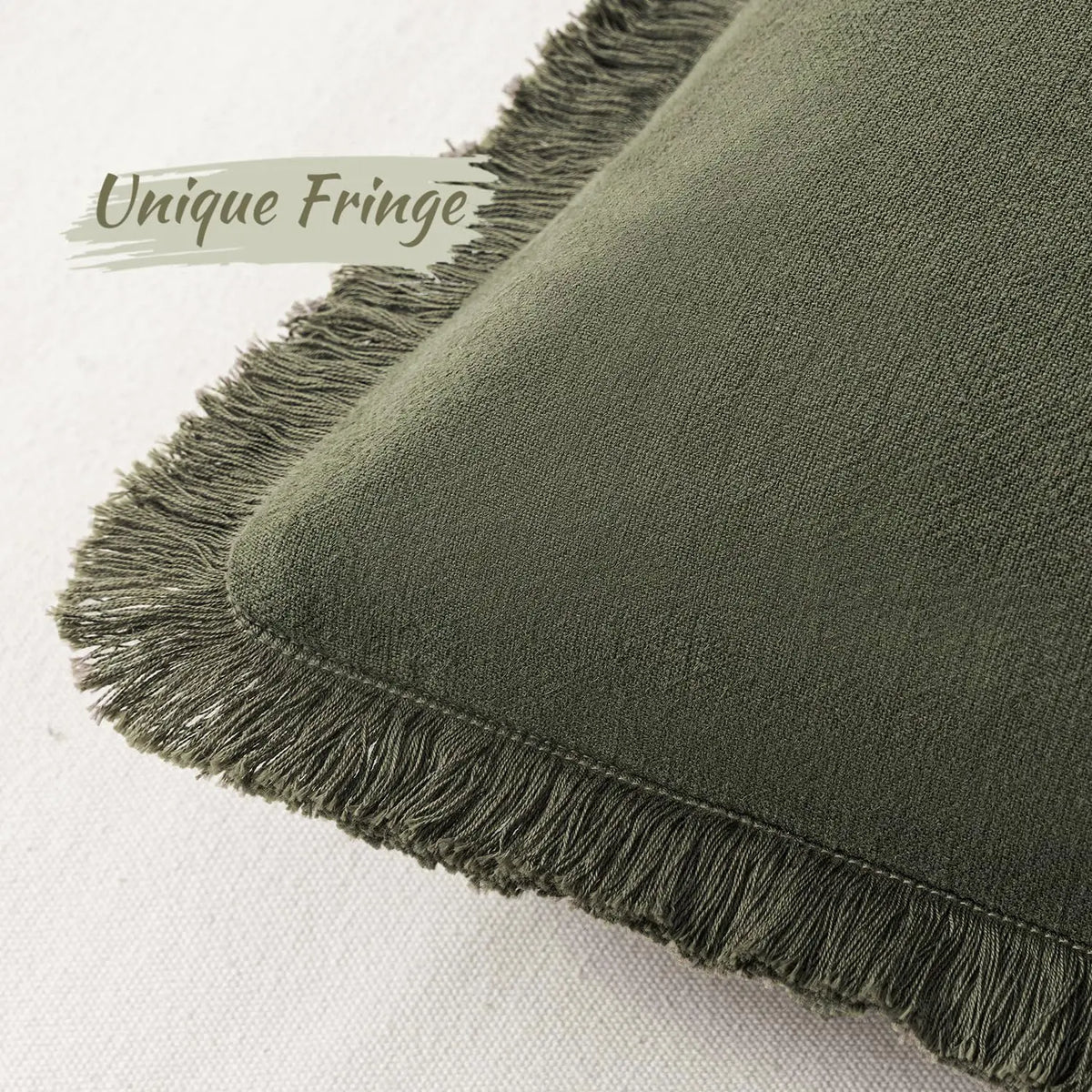 A close-up of a moss green linen throw pillow cover with unique fringe detail.