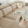 A beige jacquard elastic sofa cushion slipcover with decorative pillows and a cream-colored throw blanket.
