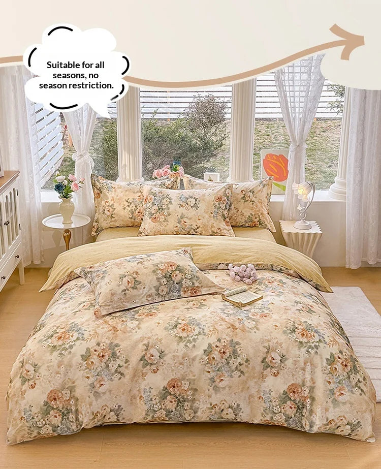 A beige floral cotton duvet cover and pillow set displayed on a bed with sheer curtains.