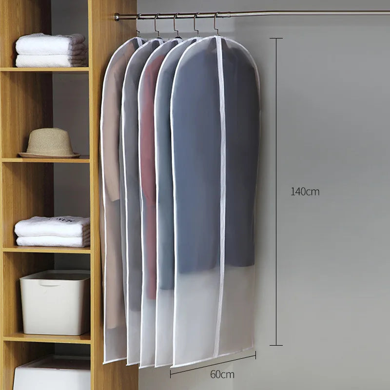 A display of transparent zippered clothes storage bags hanging on a rod against a light gray wall.
