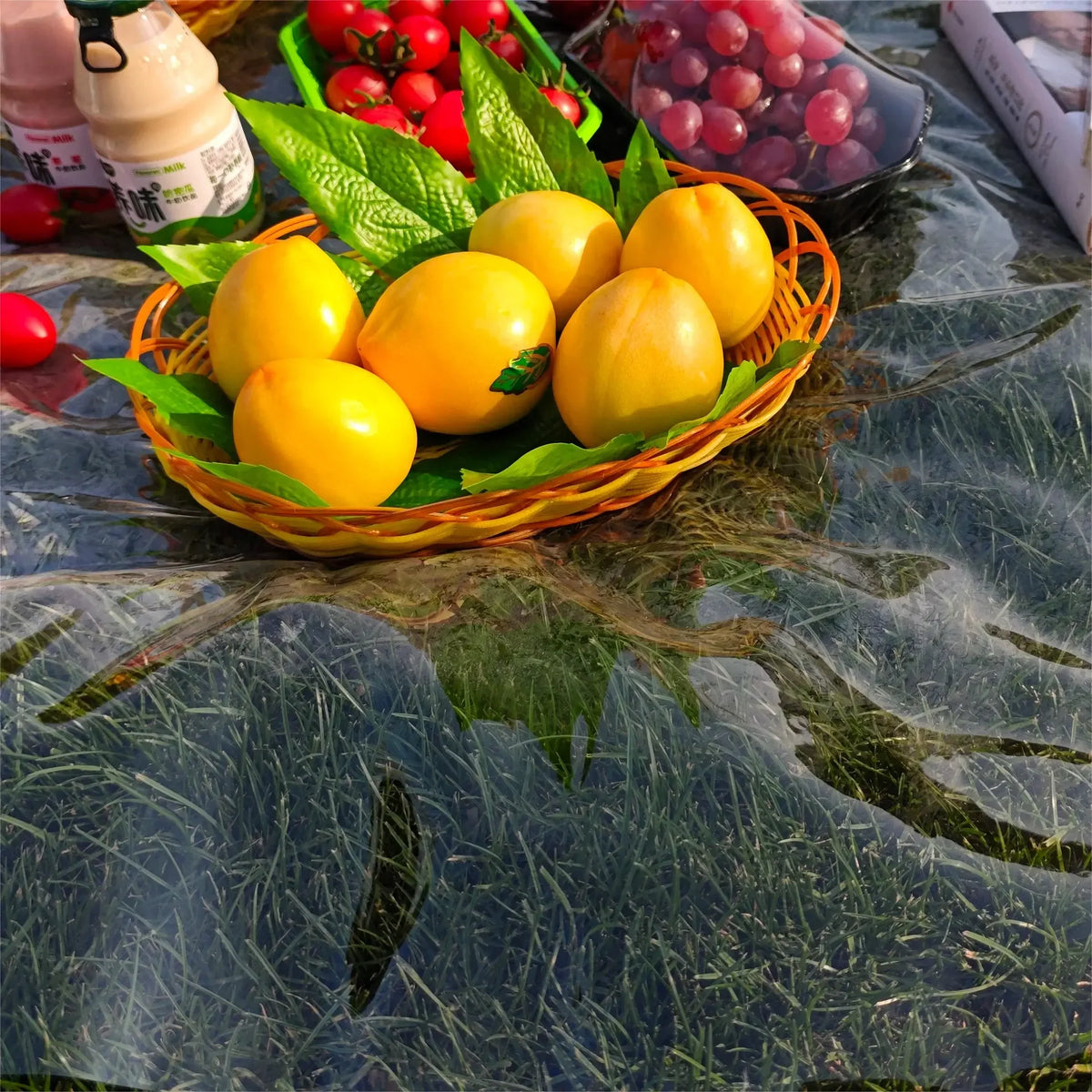 A woven basket filled with yellow lemons and green leaves placed on a dark, textured cloth.