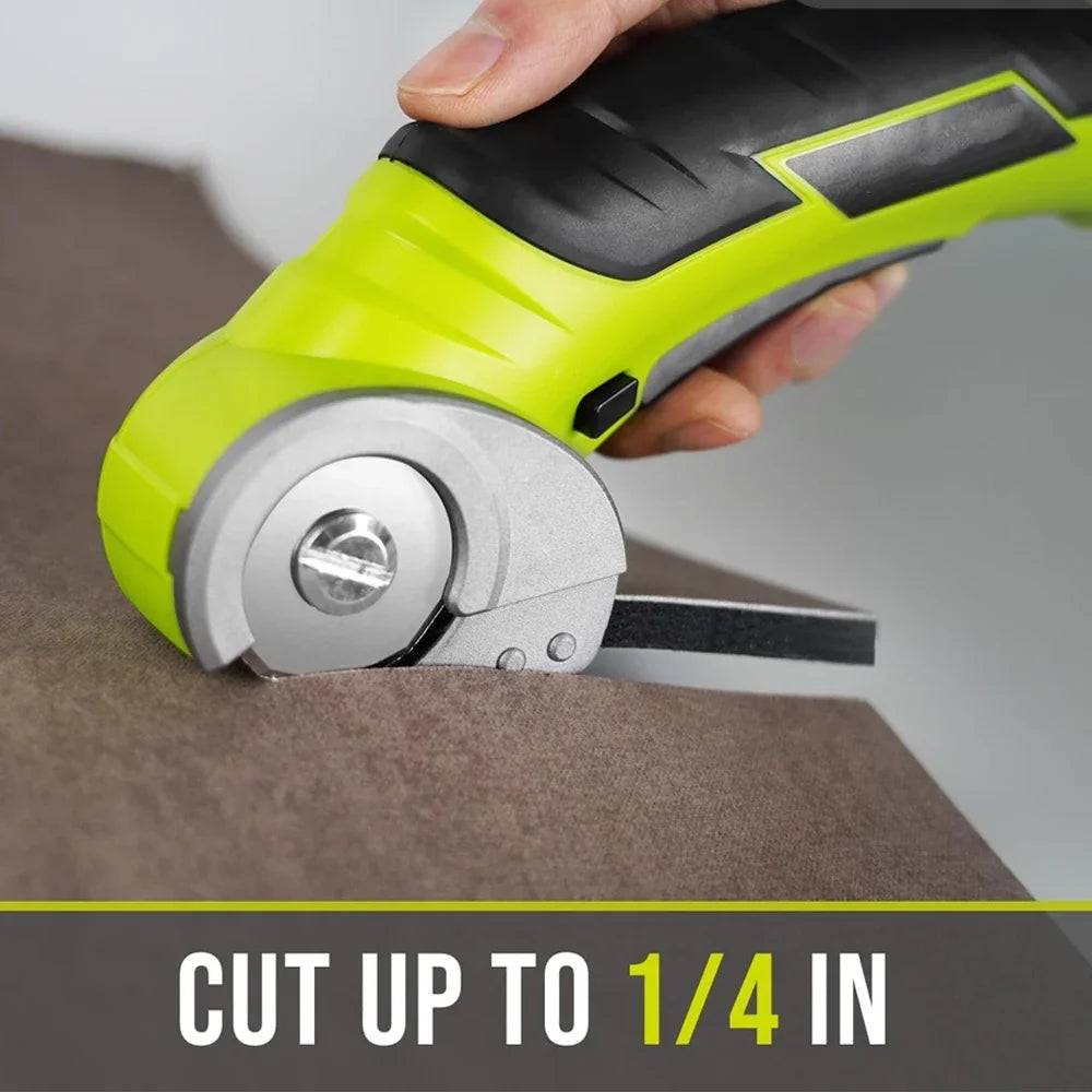 A hand holds a lime green cordless electric rotary cutter, demonstrating its use to cut cardboard.