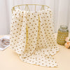 Cream printable cotton crib sheets with small gold hearts hanging on a brass hanger.