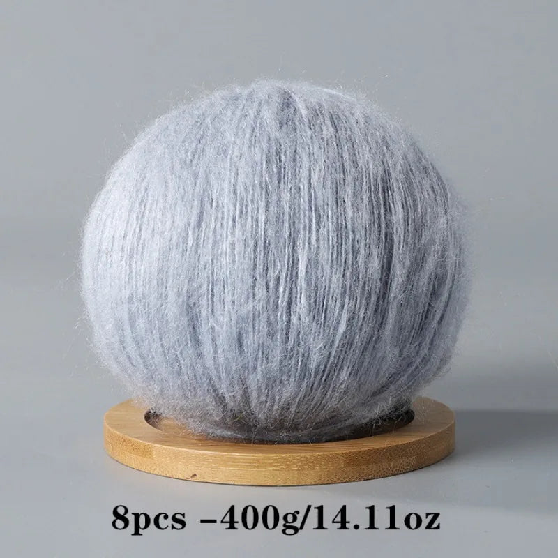 A spherical ball of gray mohair yarn used for crafting.