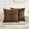 A pair of brown and black leopard print velvet pillow covers resting on a light-colored sofa.