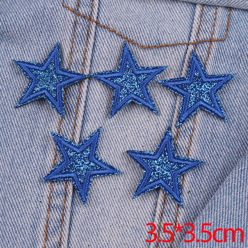 Five blue glitter star patches embroidered on denim fabric