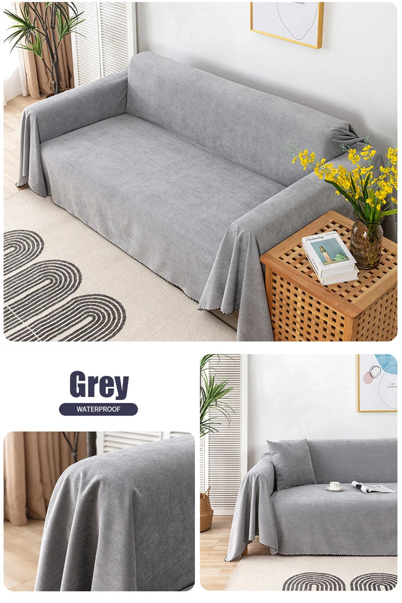 A grey waterproof sofa cover draped over a modern sofa, displayed on a light rug and next to a wooden box.