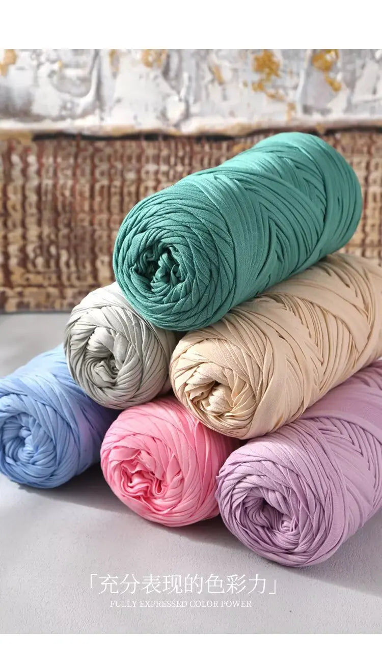 A stack of multicolored reusable elastic yarn in various shades of teal, pink, and beige for crafting