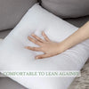A hand rests on a white throw pillow insert with bounce-back support, demonstrating comfort to lean against.