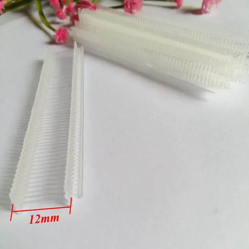 A close-up view of a white precision plastic tagging barbs for labels, showing the serrated edges and a 12mm dimension.