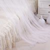 White sheer mosquito net draped over a bed, showing delicate fabric and flowing lines.
