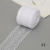 A roll of white cotton lace ribbon with floral patterns is shown next to a rolled white fabric strip.