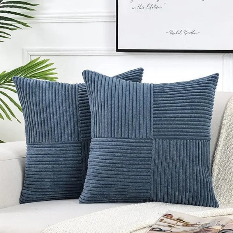 A set of navy blue corduroy patchwork pillow covers displayed on a white sofa.