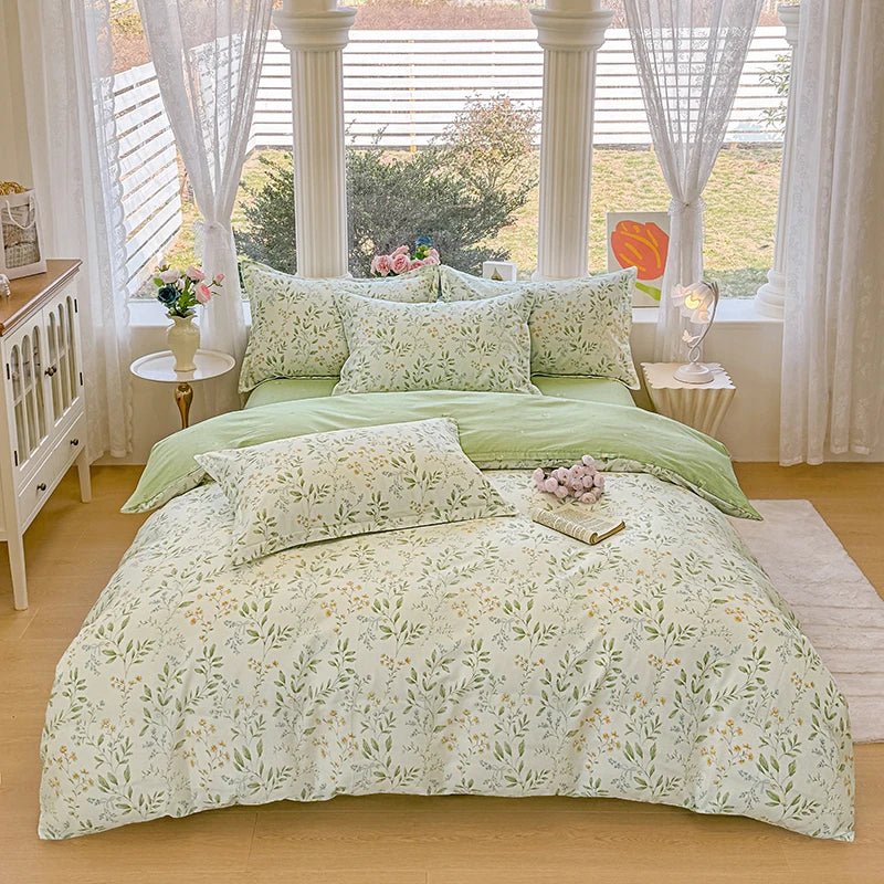 A light green floral duvet cover and pillow set displayed on a bed in a bright room with white curtains.