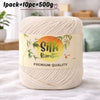 A skein of cream colored silk bamboo blend yarn is shown on a light surface with a label indicating premium quality.