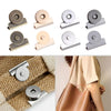 Various seamless magnetic button clasps in silver and gold tones shown on a woven bag and a leather purse.