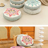 A collection of round bohemian tatami cushions in various floral and geometric patterns displayed on a light-colored rug.