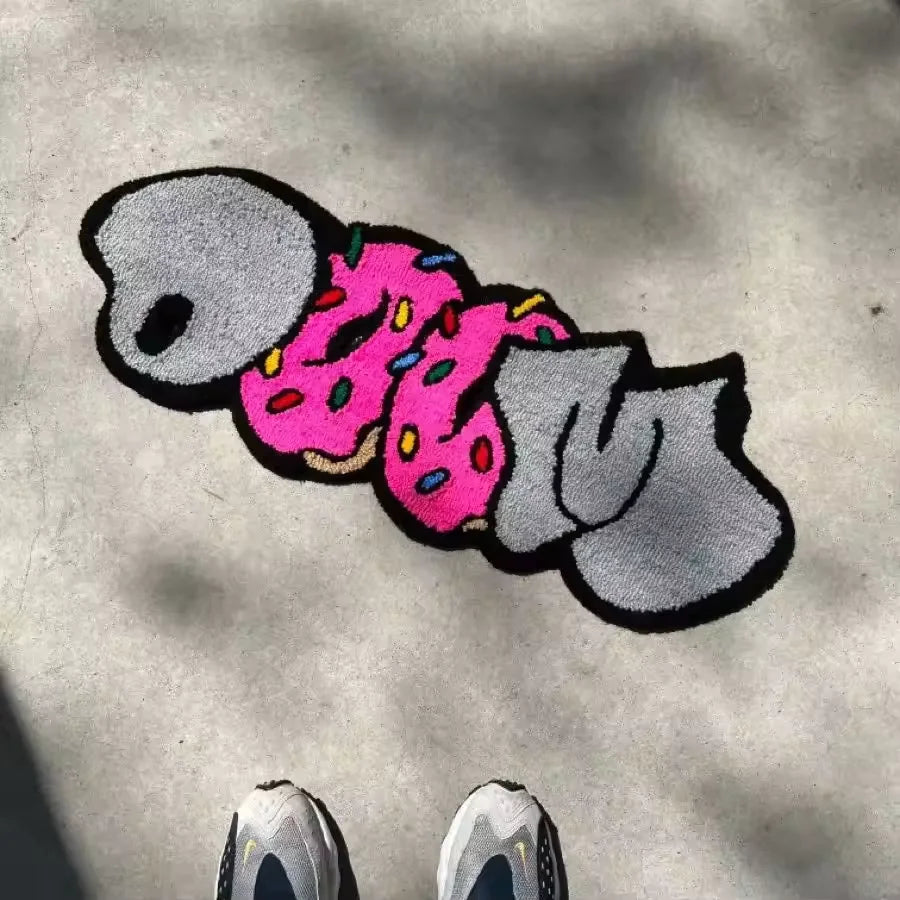 A cute cartoon decorative floor mat featuring a pink and green stylized character.