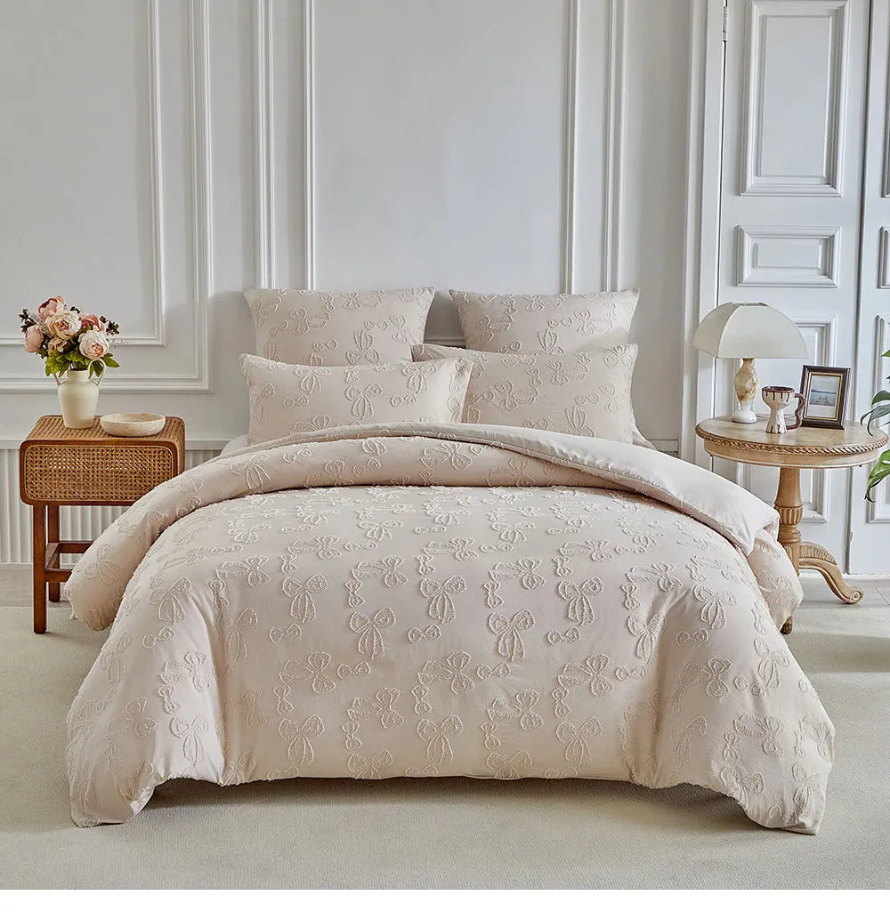 A beige luxury quilt duvet set displayed on a bed with white paneling and wooden bedside tables.