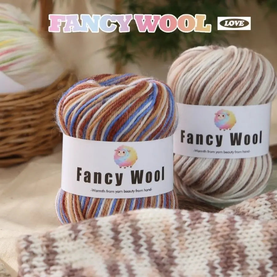 A set of Fancy Wool yarn balls in various striped colors, including brown, orange, and cream, displayed next to a knitted fab