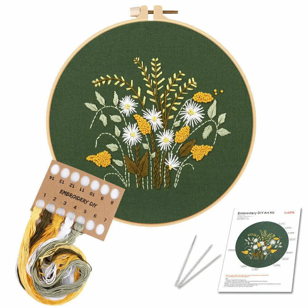 Embroidery DIY kit featuring a green fabric with yellow and white floral embroidery designs and a spool of embroidery thread