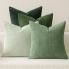 A set of four textured throw pillows in shades of sage green and pale mint green.