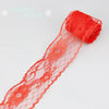 A roll of bright orange decorative lace ribbon, featuring an orange fabric and a red lace edge.