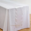 Elegant satin white table runner draped on a white tablecloth.