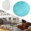 A round, bright turquoise shaggy area rug placed on a modern living room floor.